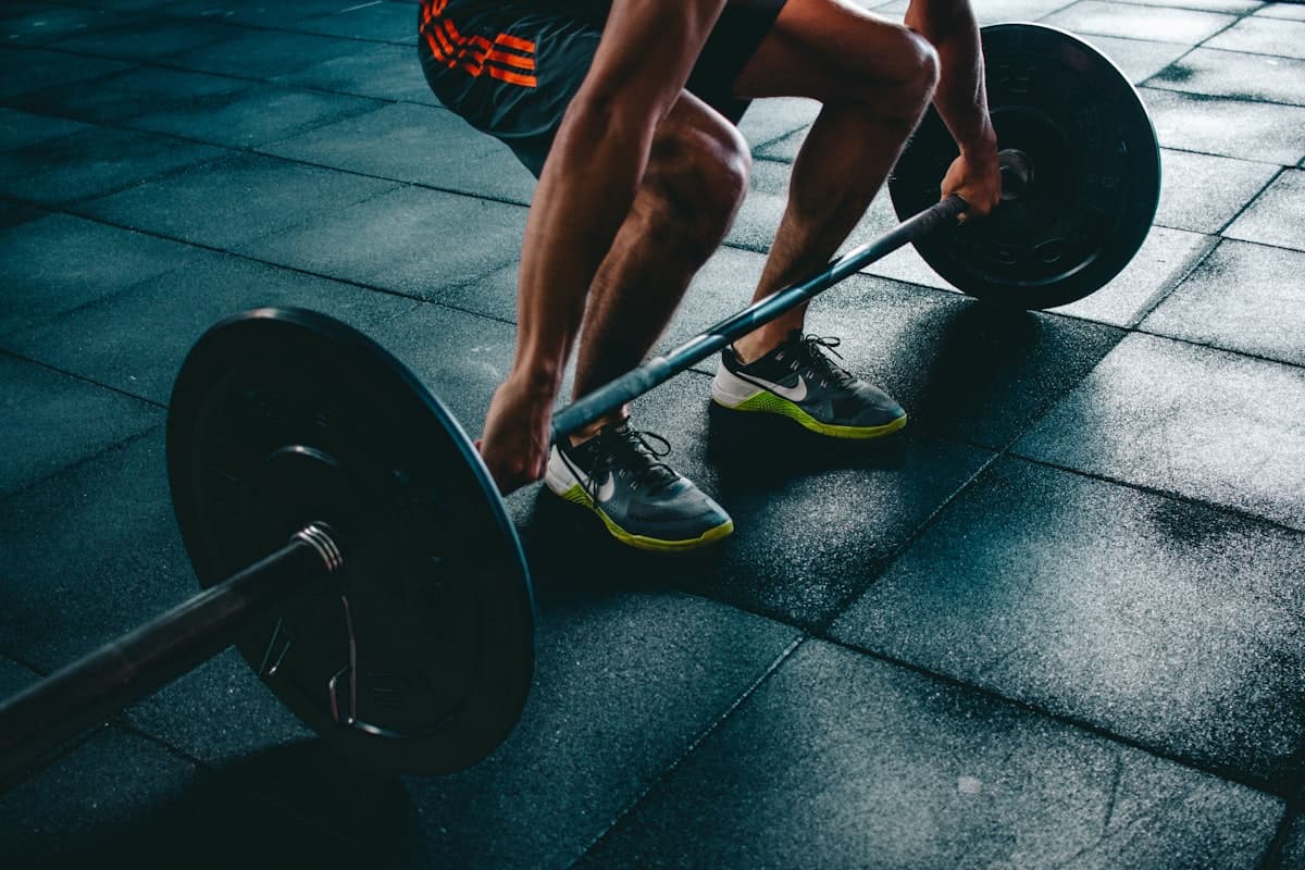 Atleta executando levantamento com barra na academia